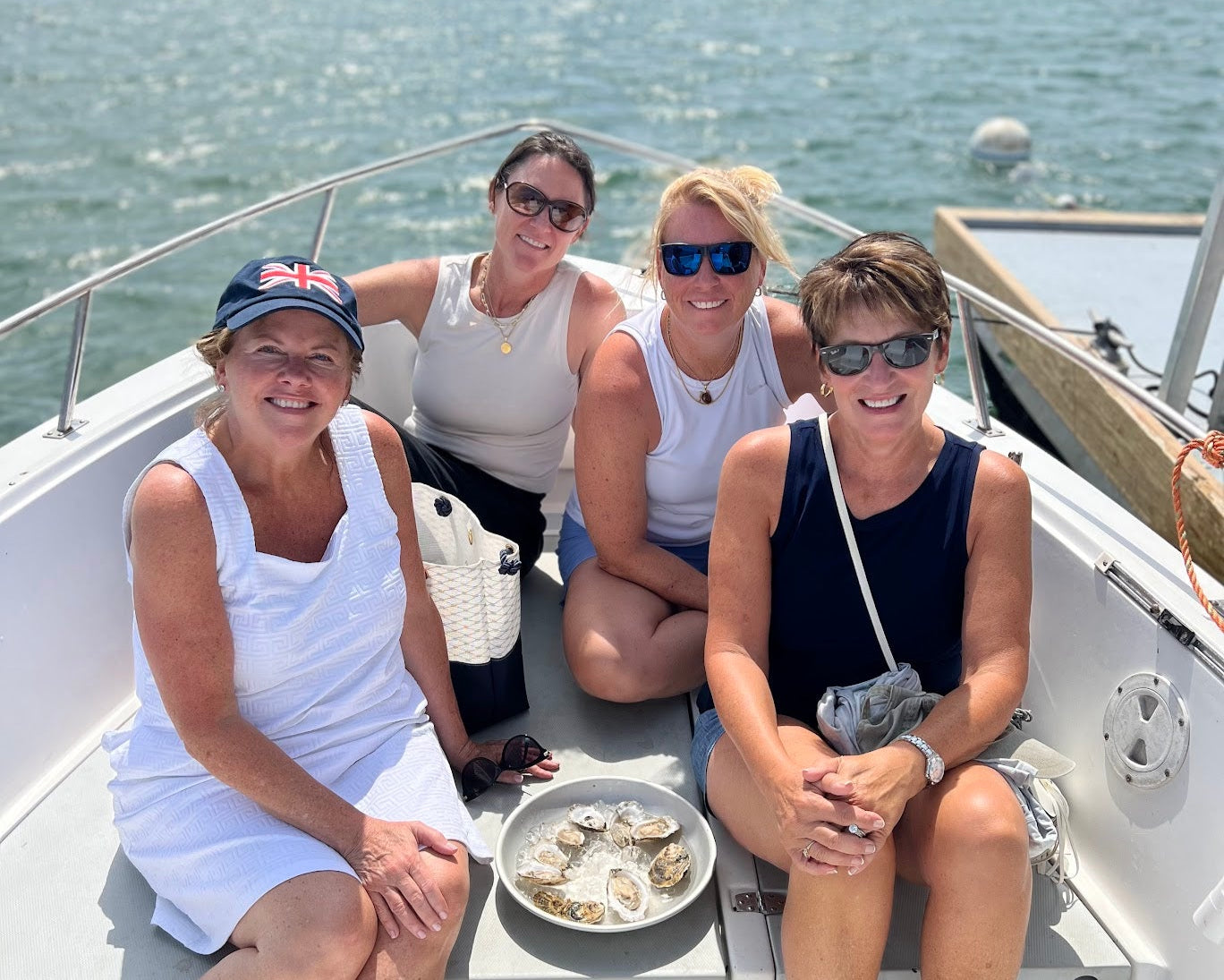 four ladies on a boat tour with a plater of oysters